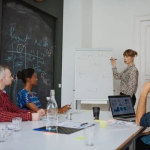 People discussing UI-UX on a whiteboard